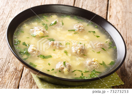 Easter festive Italian soup with meatballs, eggs, cheese close-up in a bowl. horizontal 73273253