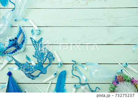 Table top view aerial image of beautiful colorful carnival festival background.Flat lay accessory object the several mask  decor confetti on modern blue wooden at home office desk studio.copy space. 73275237