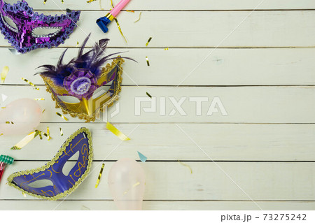Table top view aerial image of beautiful colorful carnival festival background.Flat lay accessory object the several mask  decor confetti on modern white wooden at home office desk studio.copy space. 73275242