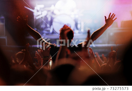 Cheering crowd in front of bright stage lights Cheering crowd in front of bright stage lights 73275573
