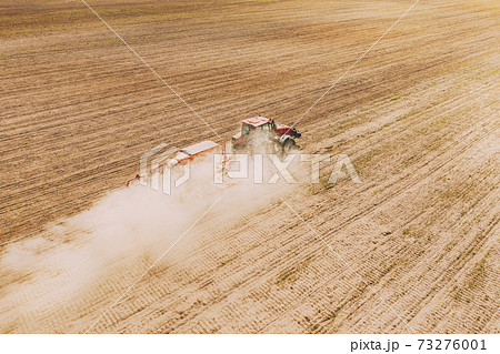Aerial View. Tractor With Seed Drill Machine Sowing The Seeds For Crops In Spring Season. Beginning Of Agricultural Spring Season. Countryside Rural Field Landscape Aerial View. Tractor With Seed Drill Machine Sowing The Seeds For Crops In Spring Season. Beginning Of Agricultural Spring Season. Countryside Rural Field Landscape 73276001