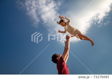 little girl 3 years flies out of daddy's hands against blue sky little girl 3 years flies out of daddy's hands against blue sky 73276085
