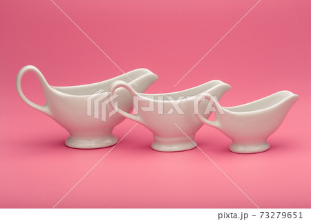 Three sauce boats of all sizes on pink background 73279651