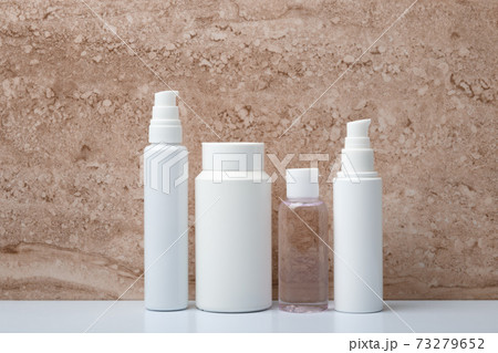 Set of unbranded beauty products for skincare on white table against marble background 73279652