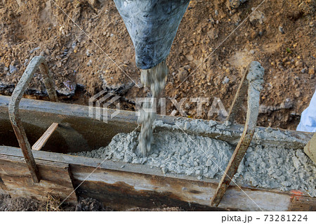 Concrete construction contractor installing a sidewalk, curb on a new urban road 73281224