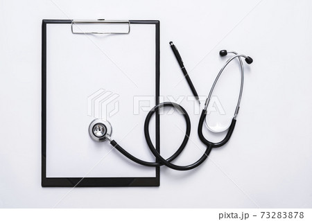 Top view of medical concept with stethoscope, clipboard and pen on white desk Top view of medical concept with stethoscope, clipboard and pen on white desk 73283878