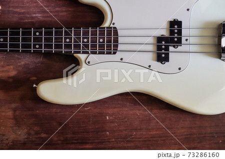 white electric bass guitar on wood background white electric bass guitar on wood background 73286160