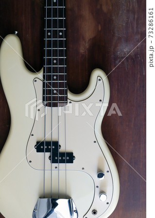 white electric bass guitar on wood background  73286161