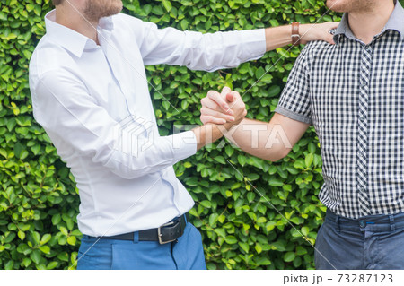 Friendship concept Hands of young friends shake hands on tree background. 73287123