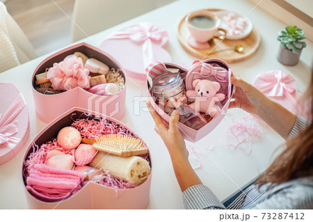 Young woman preparing birthday gift box set of natural bath supplies for body care. Young woman preparing birthday gift box set of natural bath supplies for body care. 73287412