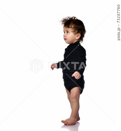Baby walking taking first step portrait isolated Baby walking taking first step portrait isolated 73287760