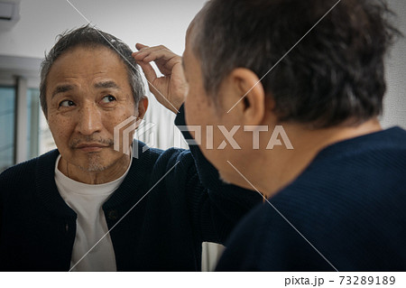 鏡越しにヘアスタイルを見て悩む中高年男性の写真素材 7321