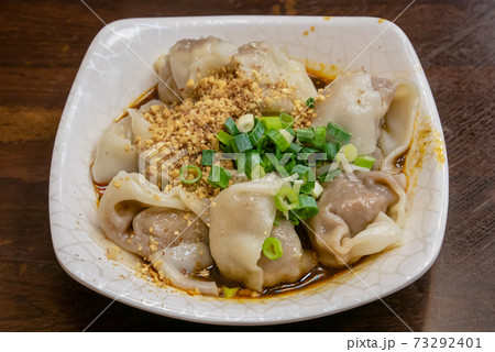 The close up of Taiwanese traditional steamed spicy stinky tofu wontons cuisine on old wooden table at food night market restaurant in Taipei, Taiwan. 73292401