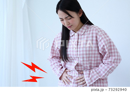 お腹が痛いパジャマ姿の女性イメージ 73292940