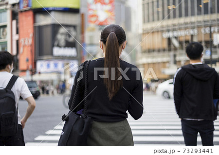 渋谷スクランブル交差点に立つ女性の後ろ姿 73293441