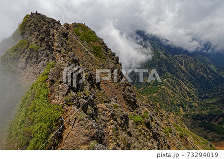 八ヶ岳連峰・赤岳から見る雲湧く竜頭峰と登山者 八ヶ岳連峰・赤岳から見る雲湧く竜頭峰と登山者 73294019