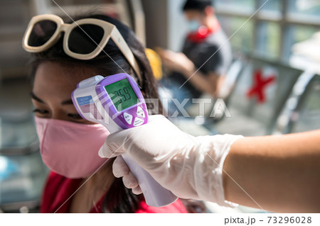 officer check passenger temperature in mask 73296028