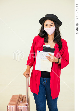 tourist in medical mask hold luggage. Holiday maker 73296033