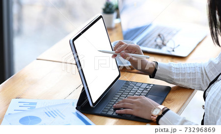 Close up view of businesswoman holding stylus pen pointing on screen of tablet computer at office desk. Close up view of businesswoman holding stylus pen pointing on screen of tablet computer at office desk. 73296869