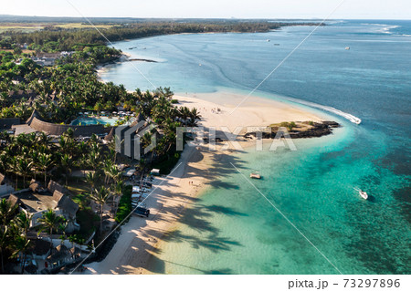 View from the height of the east coast of the island of Mauritius. Flying over the turquoise lagoon of the island of Mauritius in the area of Bel Mare. 73297896