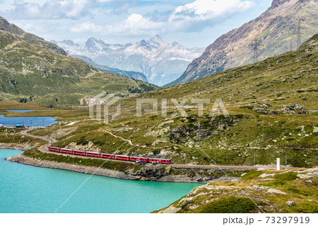 Bernina Express at the White Lake in Ospizio Bernina, Engadin, Switzerland Bernina Express at the White Lake in Ospizio Bernina, Engadin, Switzerland 73297919