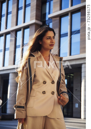 young pretty brunette woman in fashion suit at business building posing cheerful, lifestyle people concept 73298175