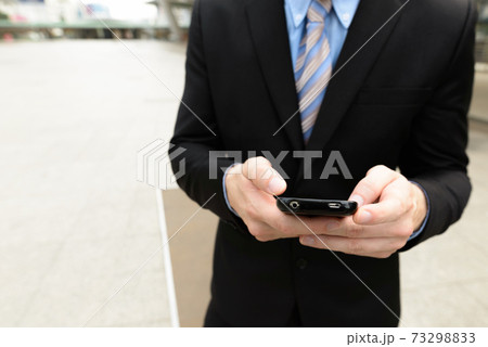 Hands of young businessman using phone in the city outdoors Hands of young businessman using phone in the city outdoors 73298833