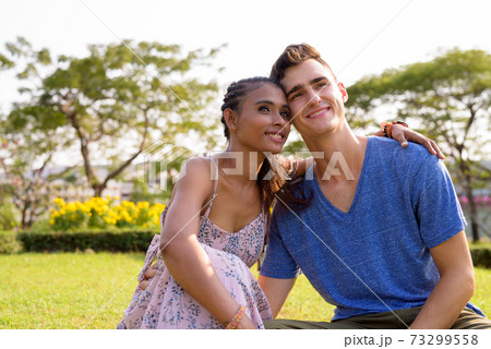 Portrait of young multi ethnic couple relaxing together at the park 73299558