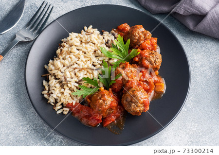 Beef meatballs and brown rice on a plate. Ready made portioned dish meat with garnish. 73300214
