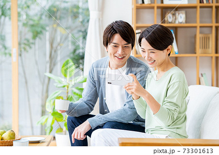 スマホで動画を見る若い夫婦の写真素材