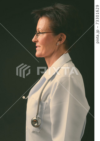 Mature beautiful woman doctor with short hair against black background Mature beautiful woman doctor with short hair against black background 73301629