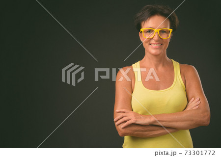 Mature beautiful woman with short hair against black background 73301772
