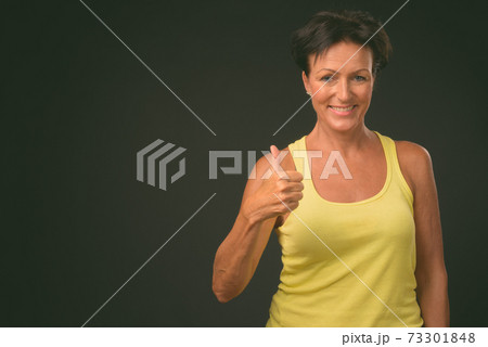 Mature beautiful woman with short hair against black background Mature beautiful woman with short hair against black background 73301848