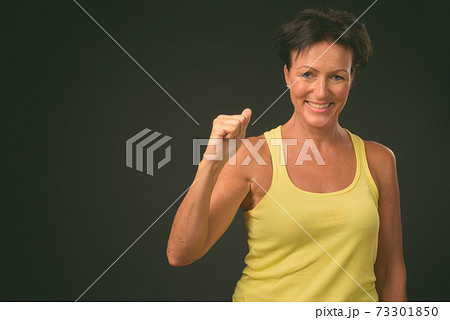 Mature beautiful woman with short hair against black background Mature beautiful woman with short hair against black background 73301850