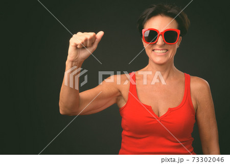 Mature beautiful woman with short hair against black background Mature beautiful woman with short hair against black background 73302046