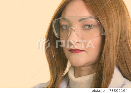 Close up of woman doctor wearing protective glasses Close up of woman doctor wearing protective glasses 73302164