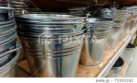 Metal galvanized buckets stand on the shelf Metal galvanized buckets stand on the shelf 73303162