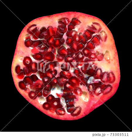 Half cut red colored juicy ripe pomegranate isolated black background 73303511