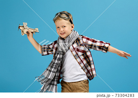 child boy in retro glasses playing with wooden toy airplane child boy in retro glasses playing with wooden toy airplane 73304283