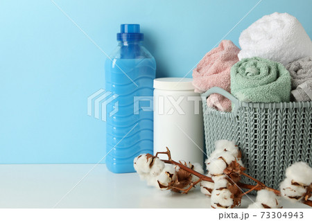 Laundry accessories on white table against blue background Laundry accessories on white table against blue background 73304943