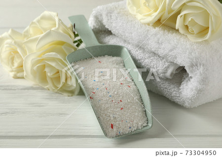 Scoop with powder, roses and towels on white wooden background Scoop with powder, roses and towels on white wooden background 73304950