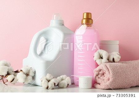 Laundry accessories on white table against pink background Laundry accessories on white table against pink background 73305391