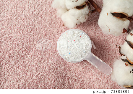 Scoop with washing powder and cotton on towel background 73305392