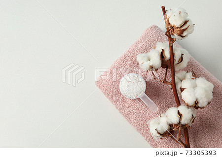 Scoop with washing powder, cotton and towel on white background Scoop with washing powder, cotton and towel on white background 73305393