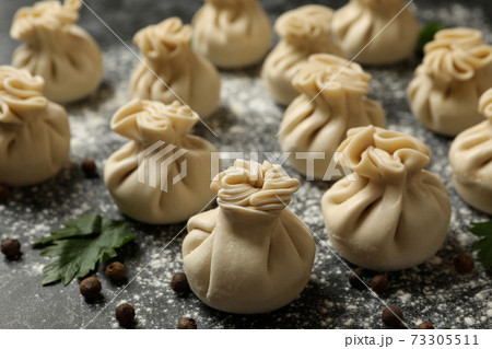 Khinkali, spices and flour on black smokey background Khinkali, spices and flour on black smokey background 73305511