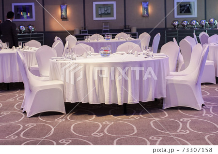 Decoration of tables and chairs in a hotel interior. Whtie textile. Empty table and chairs. Decoration of tables and chairs in a hotel interior. Whtie textile. Empty table and chairs. 73307158