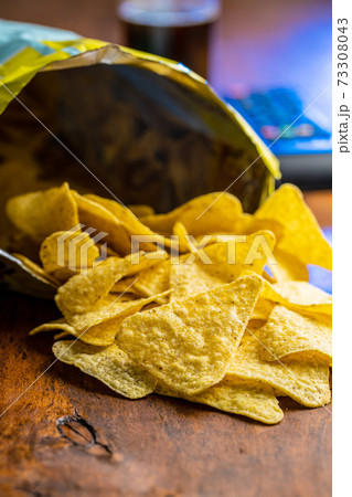 Salted tortilla chips. Yellow nachos triangle. 73308043