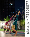 Asian weman group do yoga in city at night 73308877