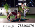 Asian weman group do yoga in city at night 73308879