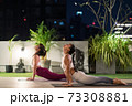 Asian women do yoga in city at night 73308881